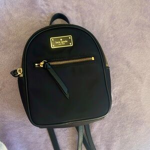 Kate Spade mini black backpack. 2 pockets with gold zippers.